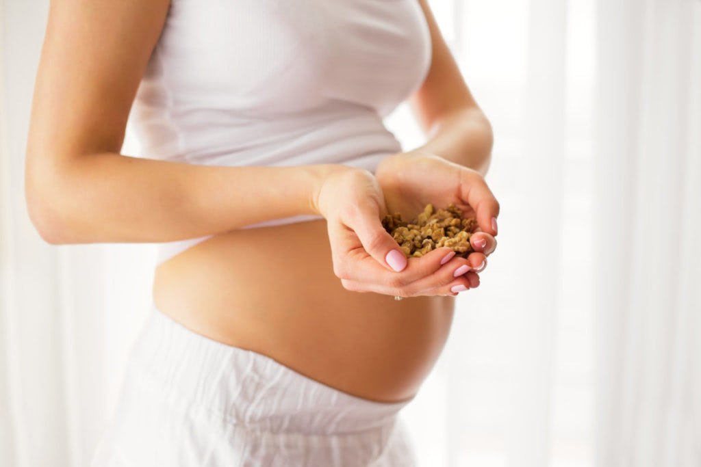 Pregnant woman holding nuts