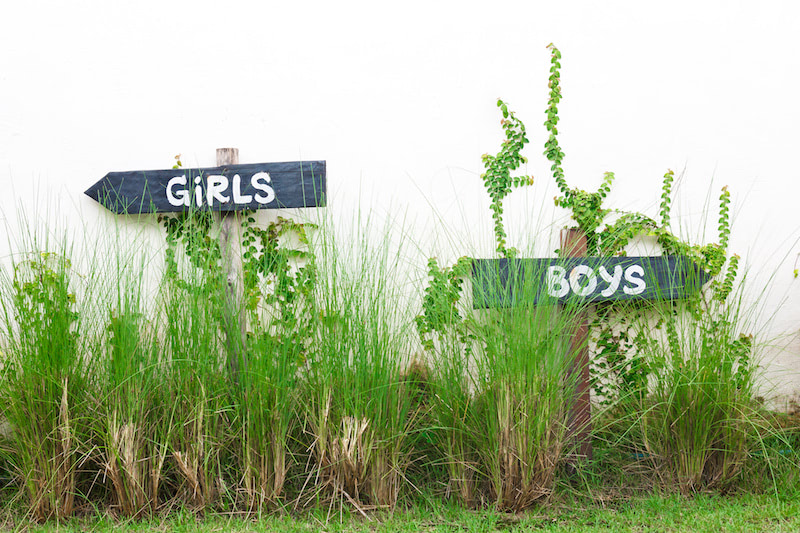 Girl and boy sign post with grass.