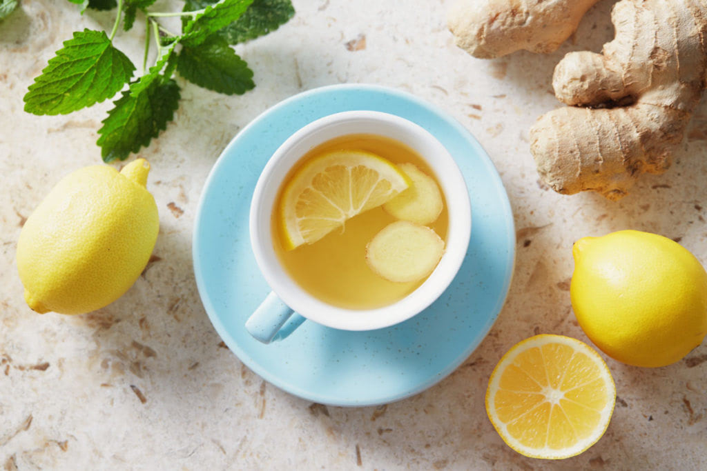 Lemon and ginger tea with honey. Cup of hot honey lemon tea with fresh ginger root.