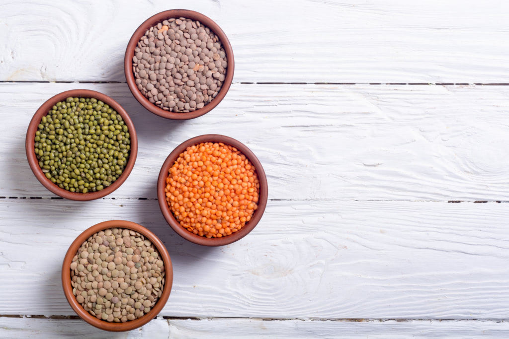 Mix of colorful lentil on wooden background . Vegan food