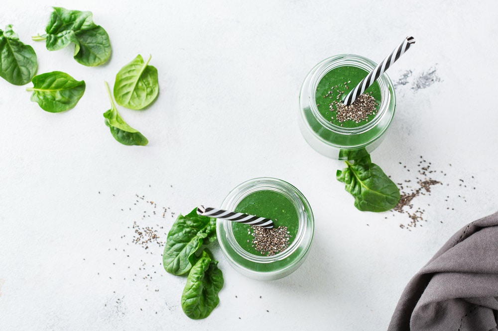 Food and drink, dieting and nutrition concept. Healthy green vegan smoothie with spinach leaves, spirulina and chia seeds for detox in summer days. Top view flat lay background
