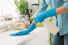 Woman cleaning with a spray detergent