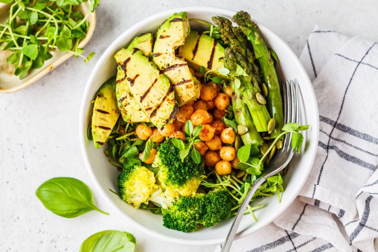 Buddha bowl with grilled avocado, asparagus, chickpeas, pea sprouts and broccoli.