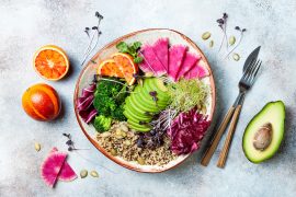 Vegan, detox Buddha bowl with quinoa, micro greens, avocado, blood orange, broccoli, watermelon radish, alfalfa seed sprouts. Top view, flat lay